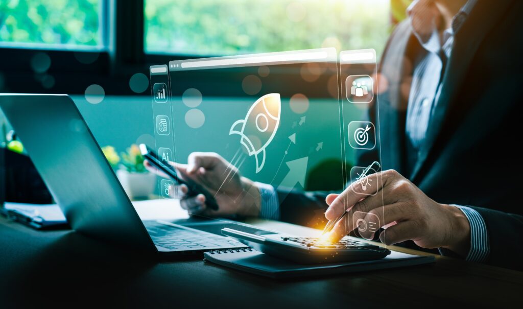 A businessperson using a laptop and smartphone, interacting with digital icons